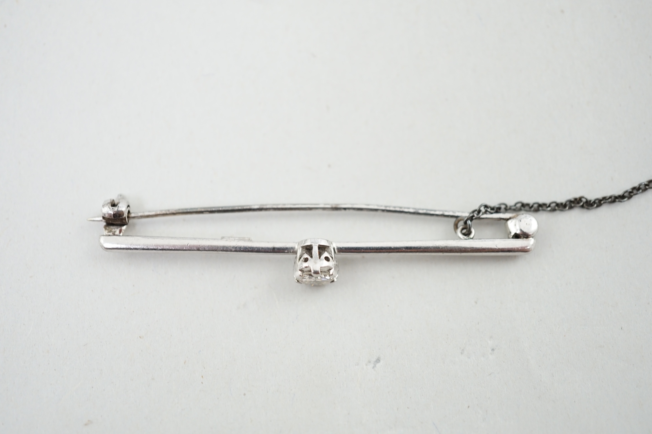 An 18ct white gold and illusion set solitaire diamond set bar brooch